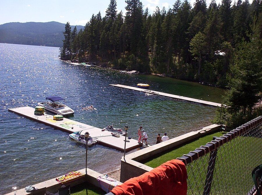Priest Lake, Idaho — a wooden dock reaching out over clear still water with forested mountains behind.